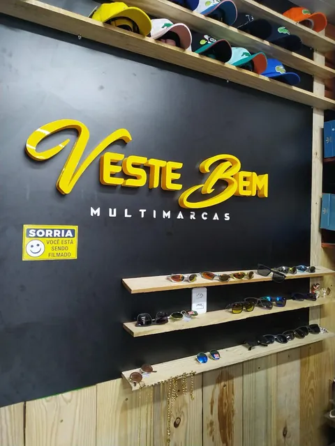 Marca dourada Veste Bem em loja. Fotografia de trabalho da VLT Acrílicos.