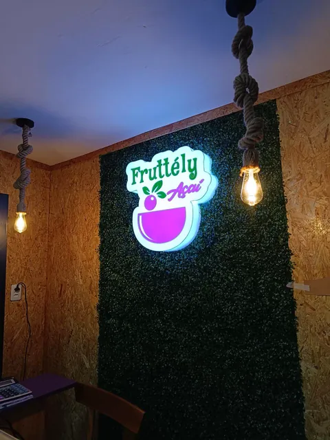 Marca iluminada Fruttely em jardim vertical. Fotografia de trabalho da VLT Acrílicos.