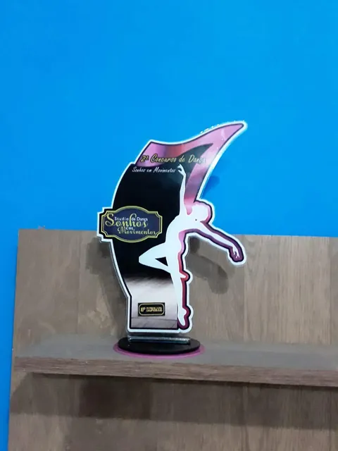 Troféu com silhueta esportiva rosa e preta. Fotografia de trabalho da VLT Acrílicos.