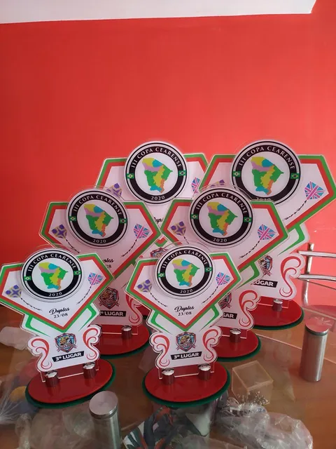 Premiação esportiva em branco, verde e vermelho. Fotografia de trabalho da VLT Acrílicos.