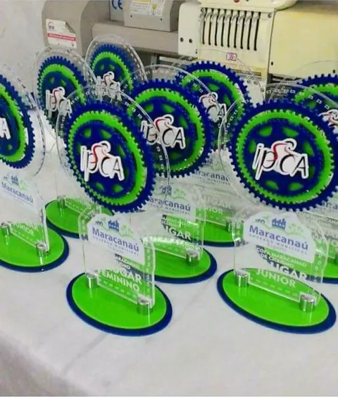Conjunto de troféus em verde e azul. Fotografia de trabalho da VLT Acrílicos.