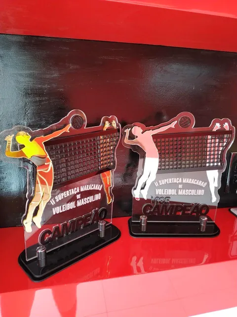 Troféus com jogadores e rede de voleibol. Fotografia de trabalho da VLT Acrílicos.