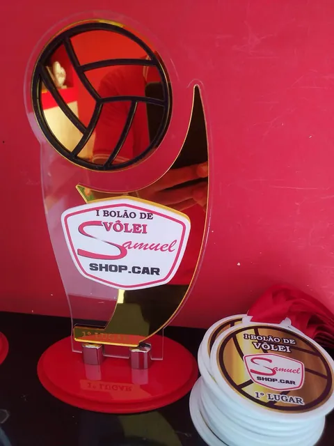 Detalhe de premiação com troféu e medalhas. Fotografia de trabalho da VLT Acrílicos.