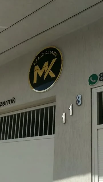 Símbolo circular e letras de identificação na fachada de uma loja.