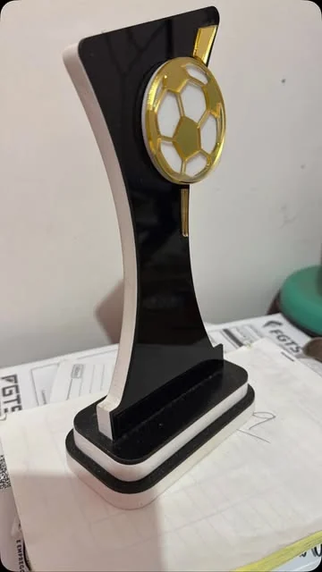 Troféu preto e branco com detalhe de bola de futebol.