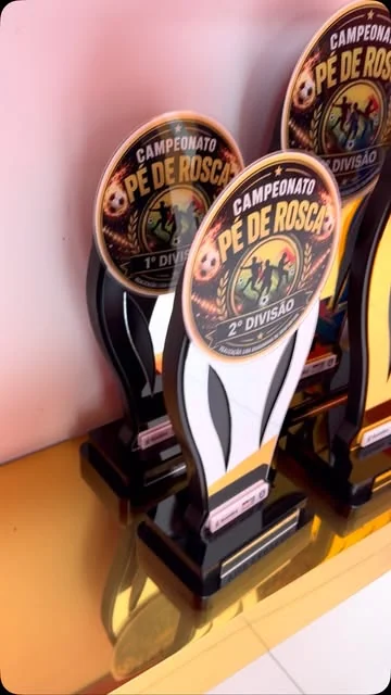 Troféus em conjunto, com peças pretas, brancas e detalhes dourados.